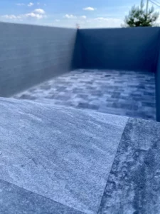 Bassin de piscine en cours d'habillage avec un PVC armé gris, Vosges