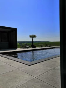 Piscine à débordement à l'eau sombre ouverte sur un panorama dégagé, Vosges