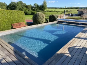 Piscine avec plage en bois ouverte sur la campagne vosgienne