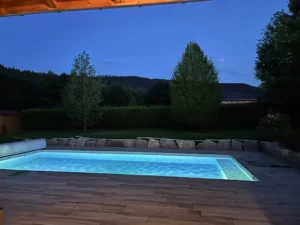 Piscine avec large terrasse en bois ouverte sur les collines vosgiennes