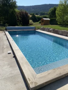 Piscine avec volet roulant ouverte sur la forêt vosgienne