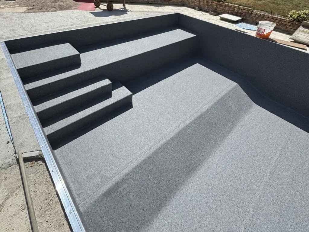 Escalier de piscine réalisé en membrane armée anthracite lors d'une rénovation à Pouxeux